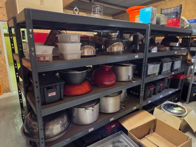 de nombreuses casseroles et poêles sur les étagères de la pièce