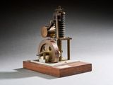une vieille maquette de machine à vapeur posée sur un socle en bois