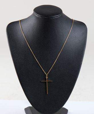 a black mannequin with a gold cross on it