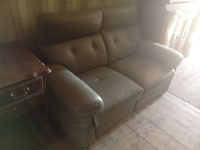 un canapé en cuir marron placé dans un salon, à côté d'une table
