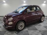 the small car is maroon in color on a checkered floor