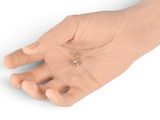 a hand that is holding a tiny piece of jewelry