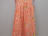 an orange and white striped dress hanging on a hanger