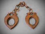 a pair of wooden handcuffs hanging from a chain