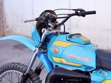 a blue dirt bike parked in front of a building