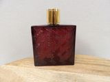a close up of a bottle of perfume on a wooden table