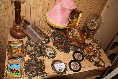 une table sur laquelle se trouvent une lampe, des cadres, des photos et d'autres photos