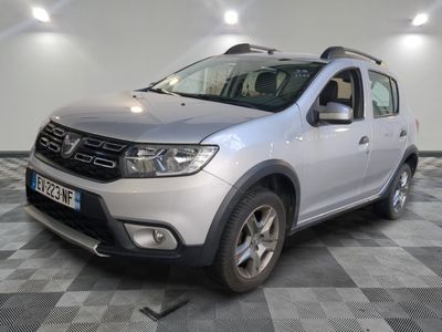 La Dacia argentée est garée sur un sol en carrelage à damier