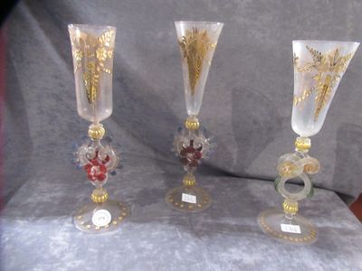 three glass vases sitting on a table next to each other