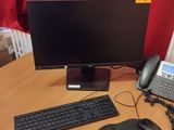 un bureau sur lequel se trouvent un ordinateur, un clavier, une souris et un téléphone