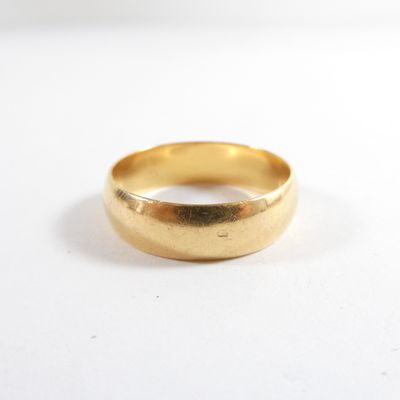gros plan d'une bague en or sur une surface blanche