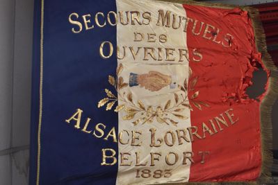 flags are hanging on the wall of a building with a flag on it