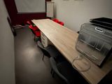 a room with a table, chairs, and a projector screen