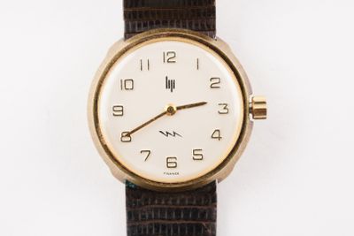 une image d'un gros plan d'une montre-bracelet sur une surface blanche