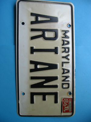 un gros plan d'une plaque d'immatriculation sur un mur bleu