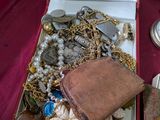 une boîte remplie de bijoux variés posée sur une table rouge