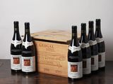 plusieurs bouteilles de vin posées sur une table à côté d'une caisse en bois