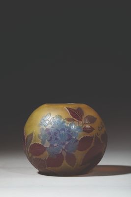 a yellow vase with blue flowers on it sitting on a table