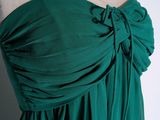 the back of a green dress with a large bow on it