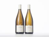 two bottles of white wine sitting on top of a table