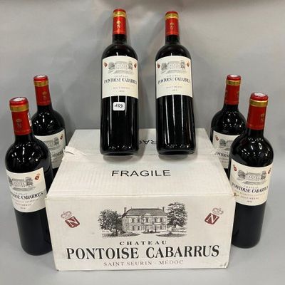 six bouteilles de vin rouge sont exposées dans une vitrine
