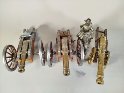 Plusieurs types différents d'armes-jouets sont alignés sur une surface blanche