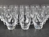 six clear wine glasses are lined up on a black surface