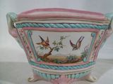 un vase rose et bleu avec des oiseaux peints dessus