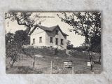 une photo d'une carte postale représentant une maison sur une colline