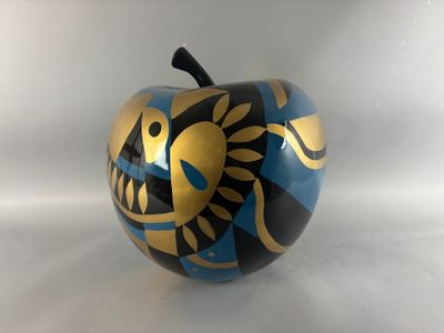 a blue and gold apple with a fish design on it