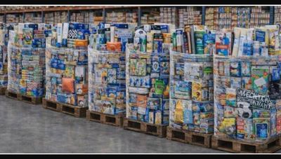 de nombreuses caisses de produits alimentaires posées sur une palette dans un magasin