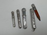 three different pens and a pencil on a table