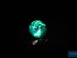 un gros plan d'une boule de verre verte posée sur une surface noire