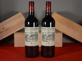 two bottles of red wine sitting next to each other on a table