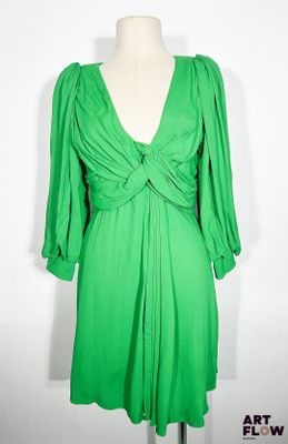 une robe verte posée sur un présentoir à mannequin, sur fond blanc