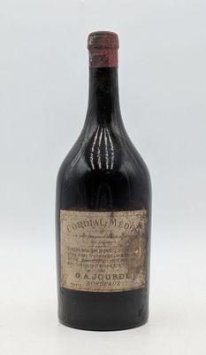 une vieille bouteille d'alcool posée sur une surface blanche