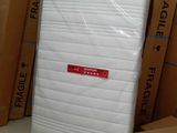 de nombreux cartons de matelas empilés par terre dans une pièce