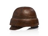 un vieux casque est posé sur une surface blanche