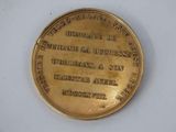 an image of a gold medal with the name of a man