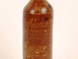 a brown vase that is sitting on a white surface