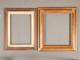 two picture frames hanging on the wall above a mirror