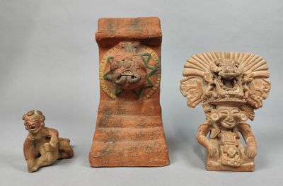 trois figurines anciennes posées les unes à côté des autres sur une table