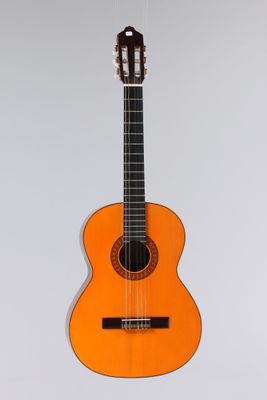 une guitare orange accrochée à un mur sur fond blanc