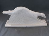 une sculpture en céramique blanche représentant un oiseau, posée sur un socle