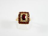 Gros plan sur une bague contenant une pierre rouge