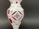 a white vase with a red and yellow design on it