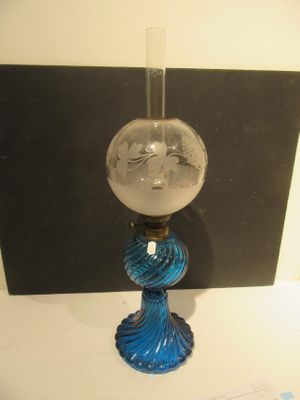 un vase en verre orné d'un visage, posé sur une table
