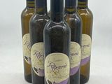 quatre bouteilles d'huile d'olive étiquetées, posées sur une table