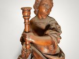 an old wooden statue of a man holding a pipe