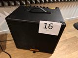 a black amp sitting on a wooden floor next to a keyboard